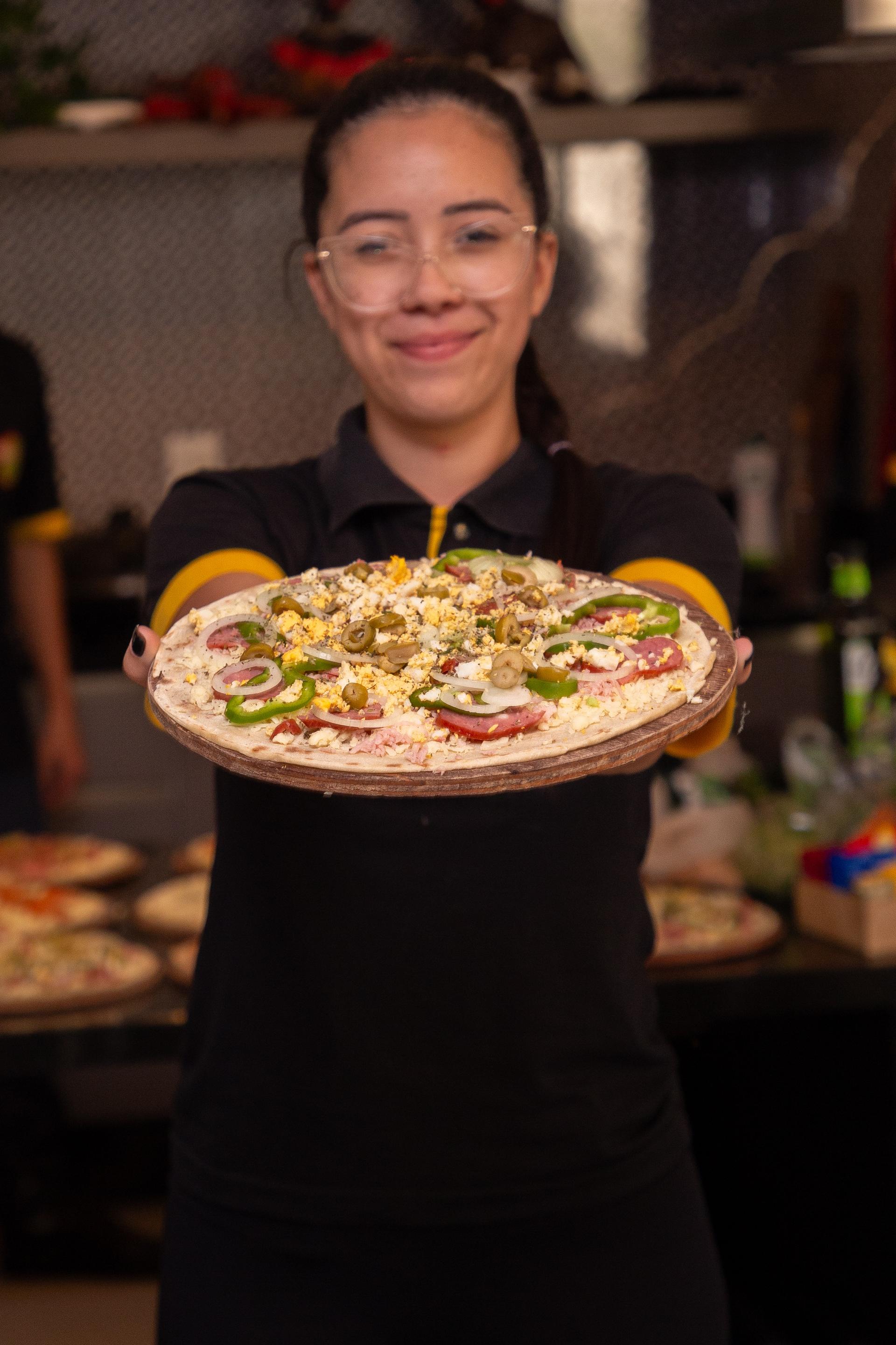Colaboradora Pizza e Companhia com pizza